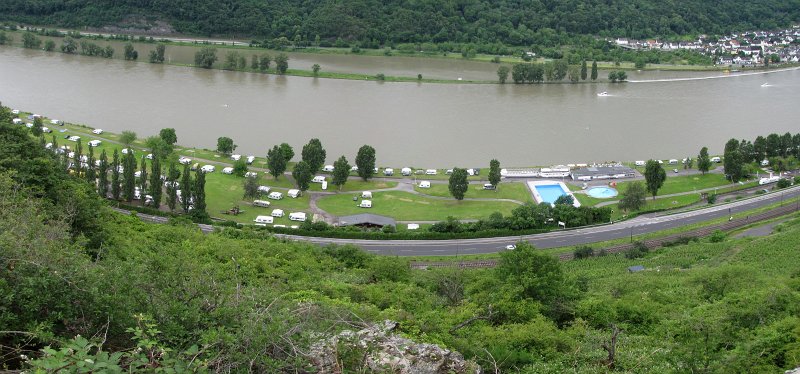 camping sonneneck.jpg - Even een foto van camping Sonneneck terwijl wij op weg zijn naar de bovenzijde van het Rijndal voor een wandeling over de Bopparder hamm richting Boppard. Waar staat onze caravan? Globaal in het midden van de foto staat een groep bomen. Links daarvan staan 2 caravans aan de Rijn. De rechter van die twee is ons mobiele huisje.